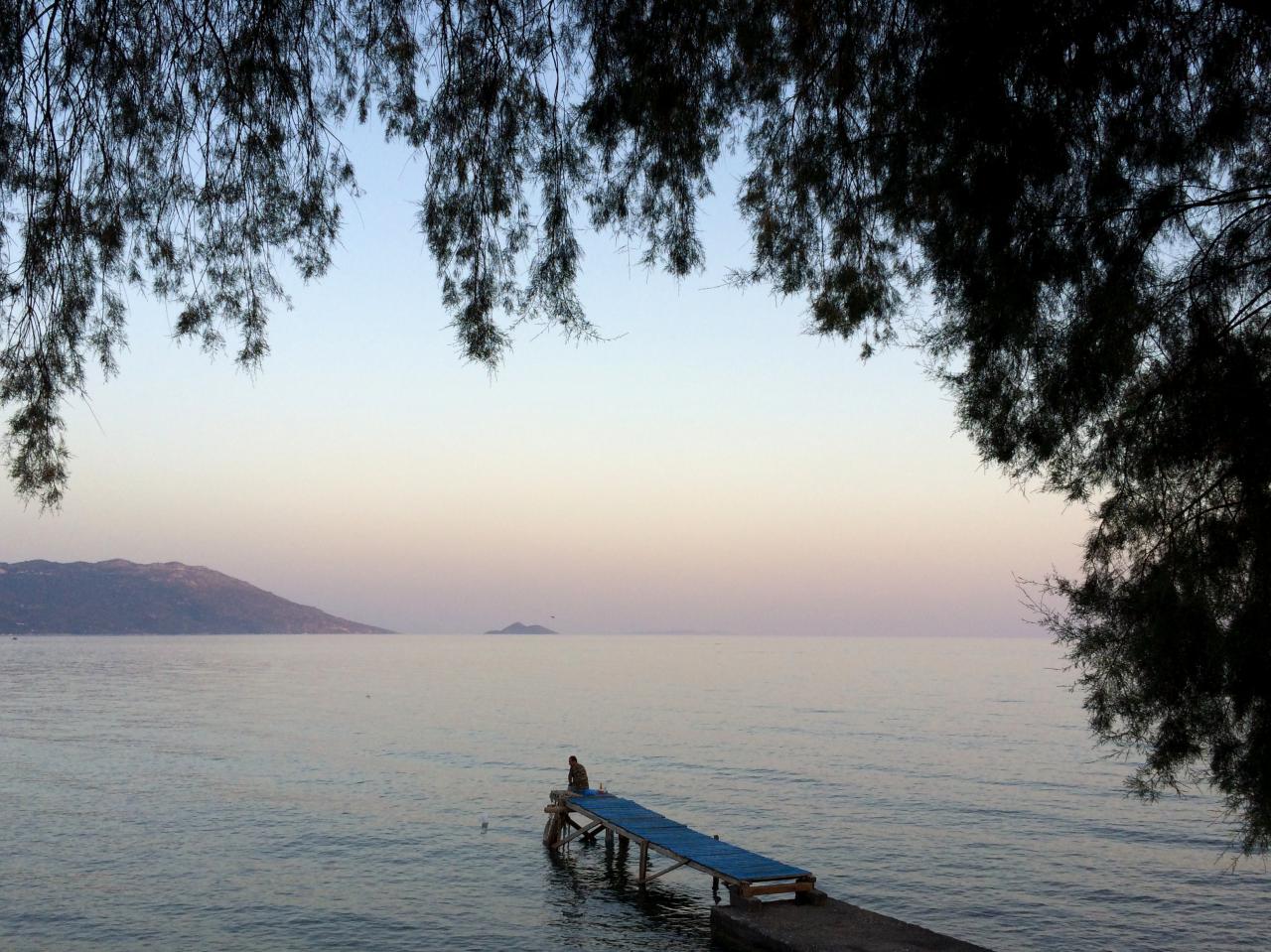 A fisherman on a wooden pier in Samos