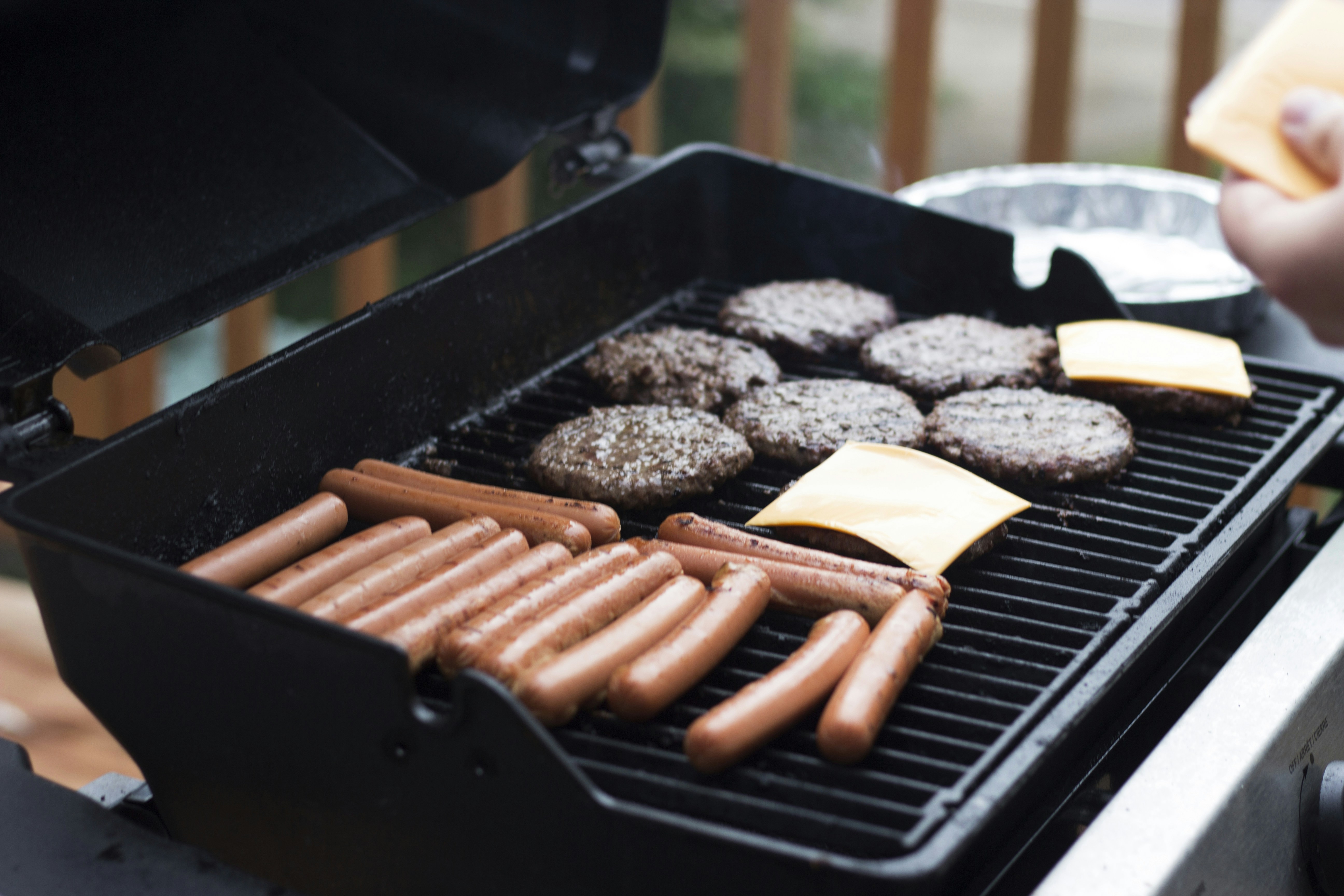 Summer grilling captured in a vibrant scene of a person standing in front of a grill, perfectly complementing the blog section on preparing your gas barbecue for success.